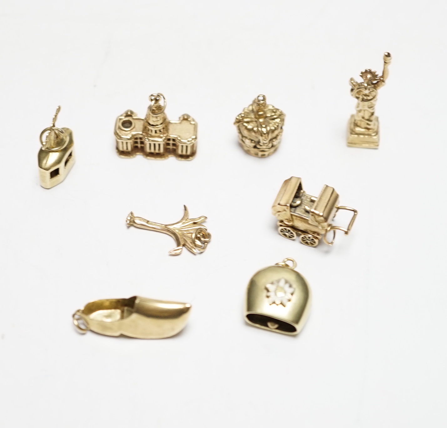 A 585 'Cable car' charm, 1.4 grams, three 9ct gold charms, 9.9 grams and four other yellow metal charms, one with enamel, gross weight 12.5 grams.